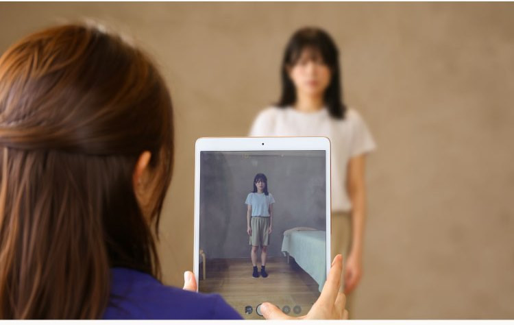 タブレットでお客様の姿勢を撮影するスタッフ