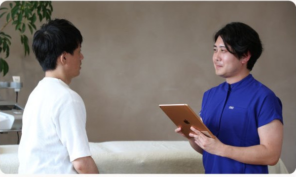 タブレットを手にお客様の話を聞くスタッフ